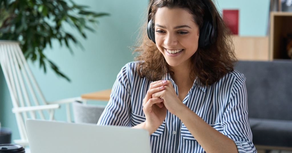 mulher com fone de ouvido em frente ao computador fazendo cursos de ouvidoria