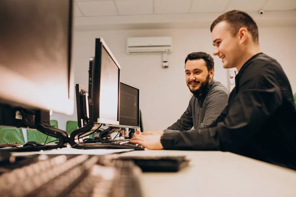 homens olhando algo em computador de trabalho